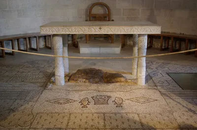 Altar da Igreja da Multiplicação dos Pães, em Tabgha, com a rocha venerada embaixo e, à frente, o mosaico antigo de um cesto de pães entre dois peixes