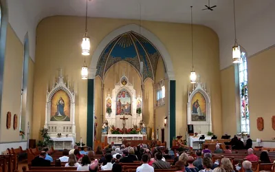 Igreja enfeitada com convidados antes de missa de casamento